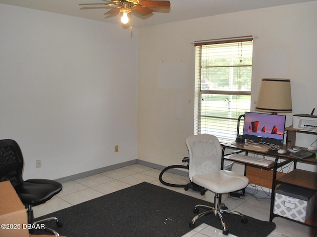 office featuring plenty of natural light, baseboards, ceiling fan, and light tile patterned floors