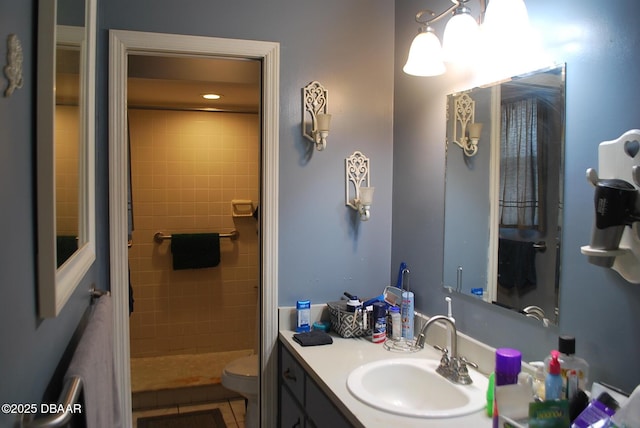 bathroom featuring tile patterned flooring, a shower stall, toilet, and vanity