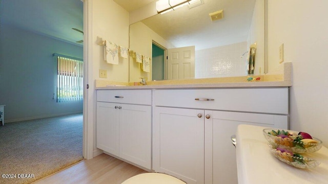 bathroom with wood-type flooring, toilet, and vanity