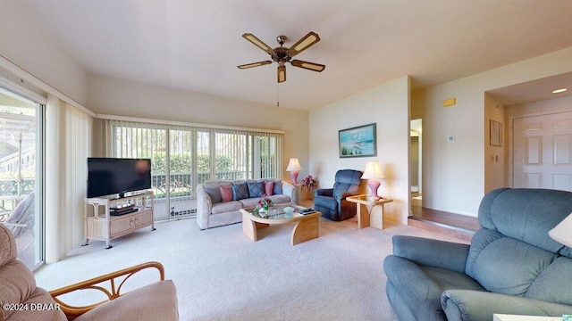 living room with a wealth of natural light, ceiling fan, and light carpet