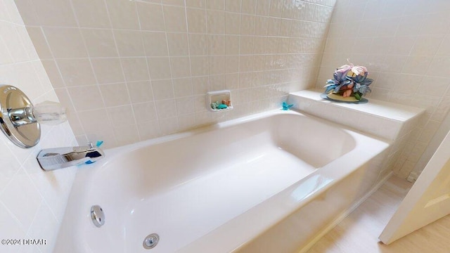 bathroom featuring tile walls and a bathing tub