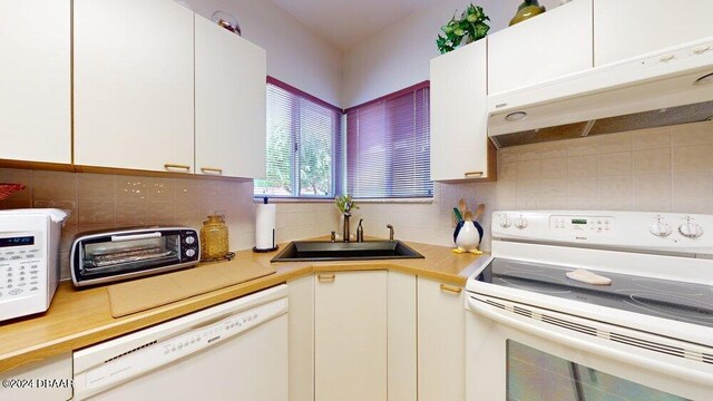 kitchen with white cabinetry, tasteful backsplash, white appliances, and sink