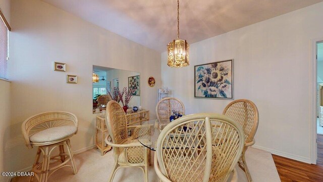 dining area with wood-type flooring and a notable chandelier