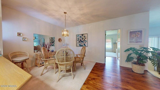 dining area featuring a wealth of natural light, vaulted ceiling, and hardwood / wood-style flooring