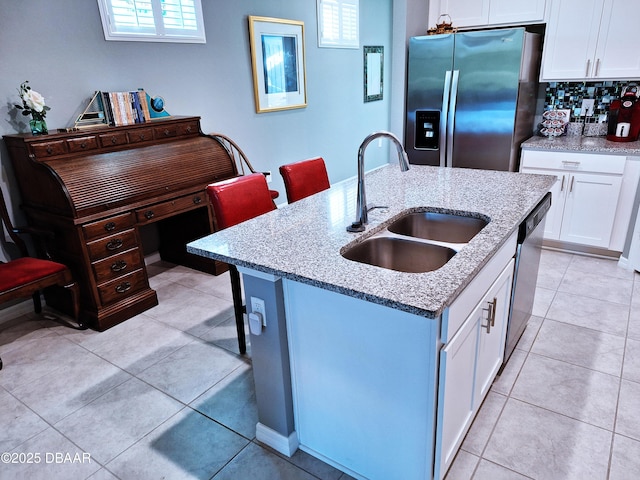 3107 Crab Trap Dr, New Smyrna Beach, FL 32168 - kitchen with stainless steel appliances, a sink, white cabinetry, a kitchen island with sink, and light stone counters