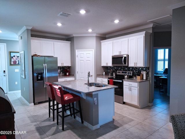 3107 Crab Trap Dr, New Smyrna Beach, FL 32168 - kitchen featuring stainless steel appliances, a sink, backsplash, light stone counters, and a center island with sink