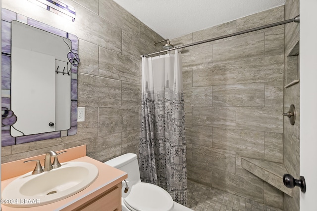 bathroom featuring vanity, toilet, a textured ceiling, tile walls, and walk in shower