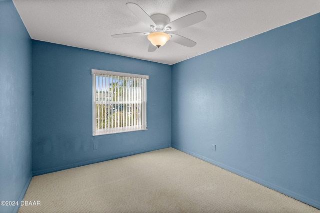 unfurnished room with light carpet, ceiling fan, and a textured ceiling