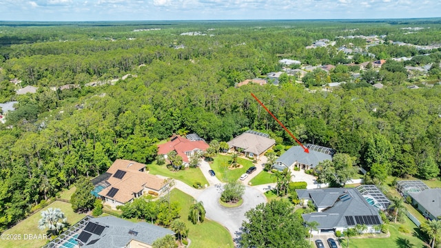 aerial view of property and surrounding area with a forest and nearby suburban area