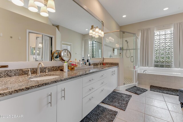 bathroom featuring tile patterned flooring, healthy amount of natural light, a bath, a shower stall, and recessed lighting