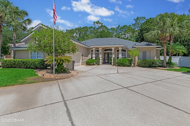 view of front of home featuring french doors, concrete driveway, an attached garage, and stucco siding