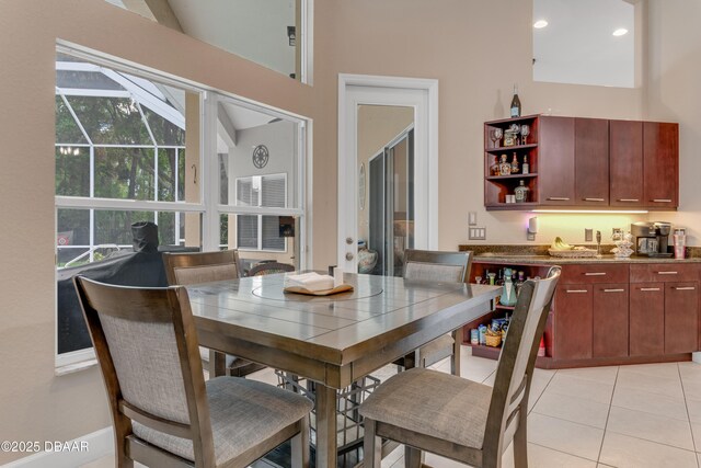 dining space with light tile patterned flooring, lofted ceiling, and recessed lighting