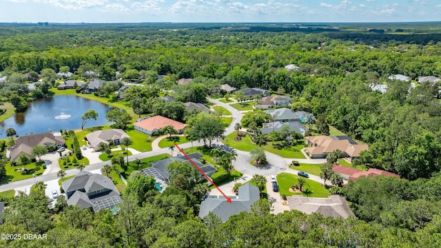 view of property location with a forest, nearby suburban area, and a large body of water