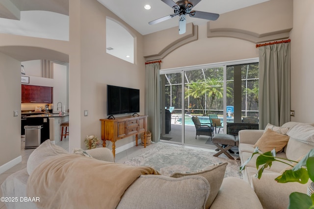living area with a ceiling fan, arched walkways, high vaulted ceiling, light tile patterned flooring, and recessed lighting