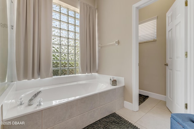 bathroom with tile patterned floors, a bath, and baseboards