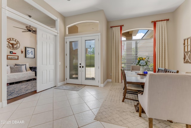 entryway with french doors, light tile patterned floors, baseboards, and arched walkways