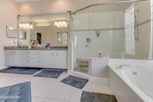full bath featuring a stall shower, a chandelier, a garden tub, double vanity, and tile patterned floors