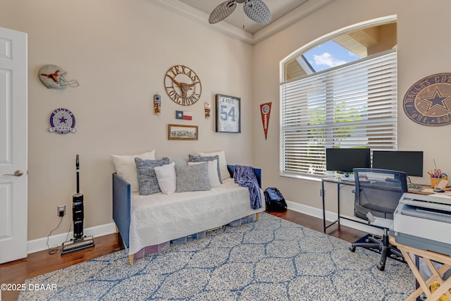 office featuring wood finished floors, ceiling fan, and baseboards