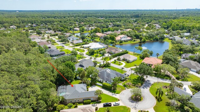 aerial perspective of suburban area featuring a heavily wooded area and a nearby body of water