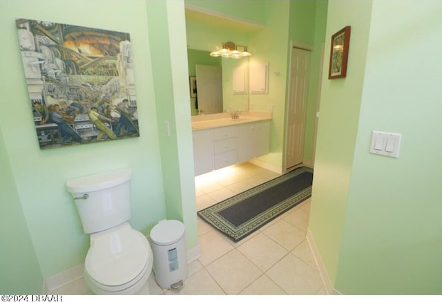 bathroom with toilet, vanity, and tile patterned floors