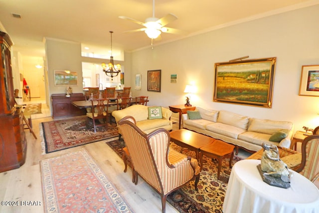 living room with ceiling fan with notable chandelier, light hardwood / wood-style flooring, and crown molding