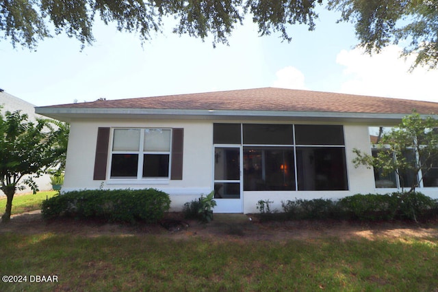 view of property exterior with a sunroom and a yard