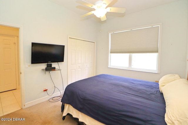 bedroom featuring ceiling fan, light carpet, and a closet