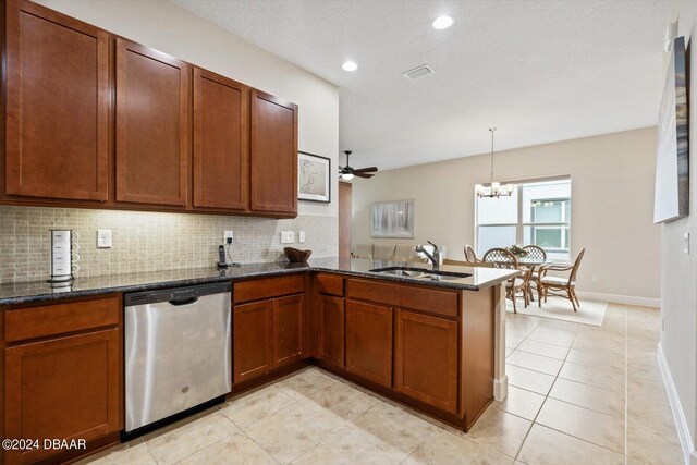 kitchen featuring sink, kitchen peninsula, backsplash, stainless steel dishwasher, and hanging light fixtures