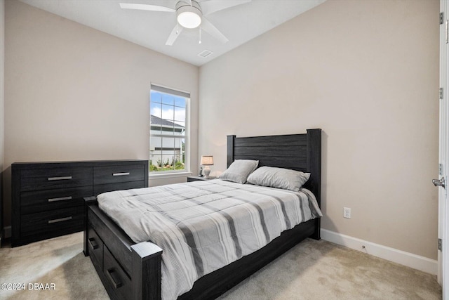 bedroom with light colored carpet, lofted ceiling, and ceiling fan