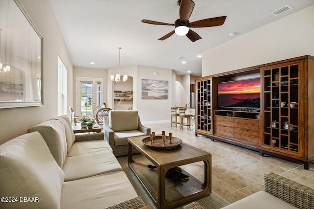 tiled living room with ceiling fan with notable chandelier