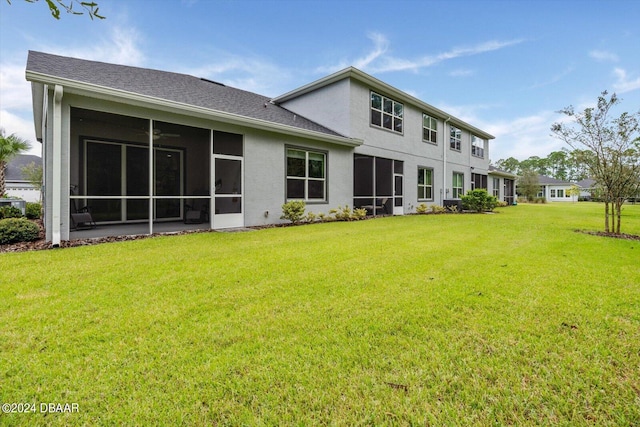 rear view of property featuring a sunroom and a yard