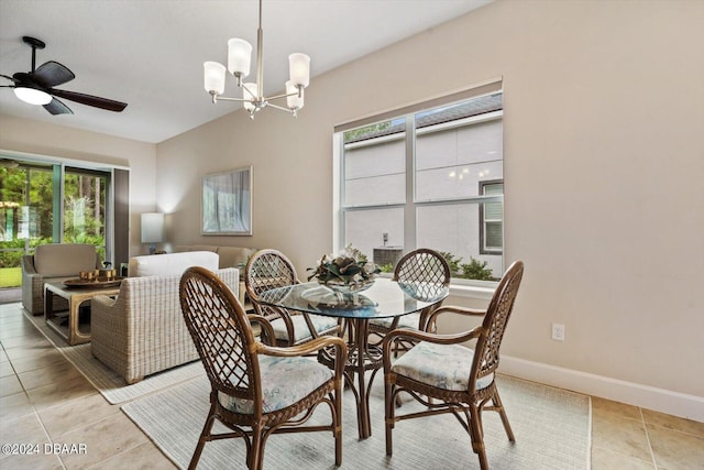 dining space with ceiling fan with notable chandelier and light tile patterned flooring