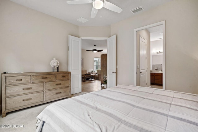 bedroom featuring connected bathroom, light colored carpet, and ceiling fan