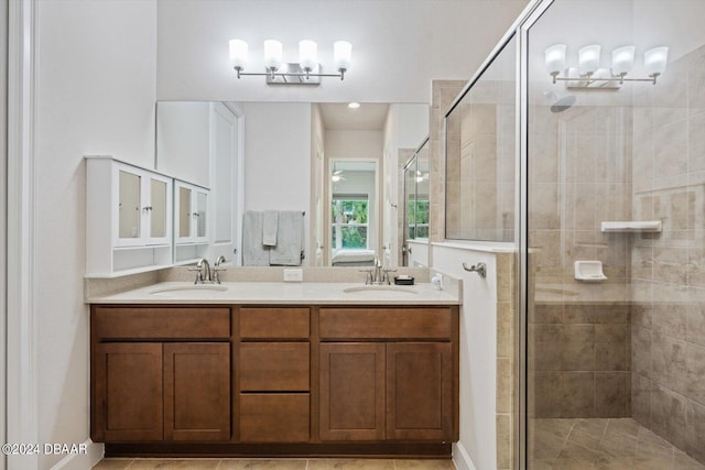 bathroom with an enclosed shower, vanity, and tile patterned flooring