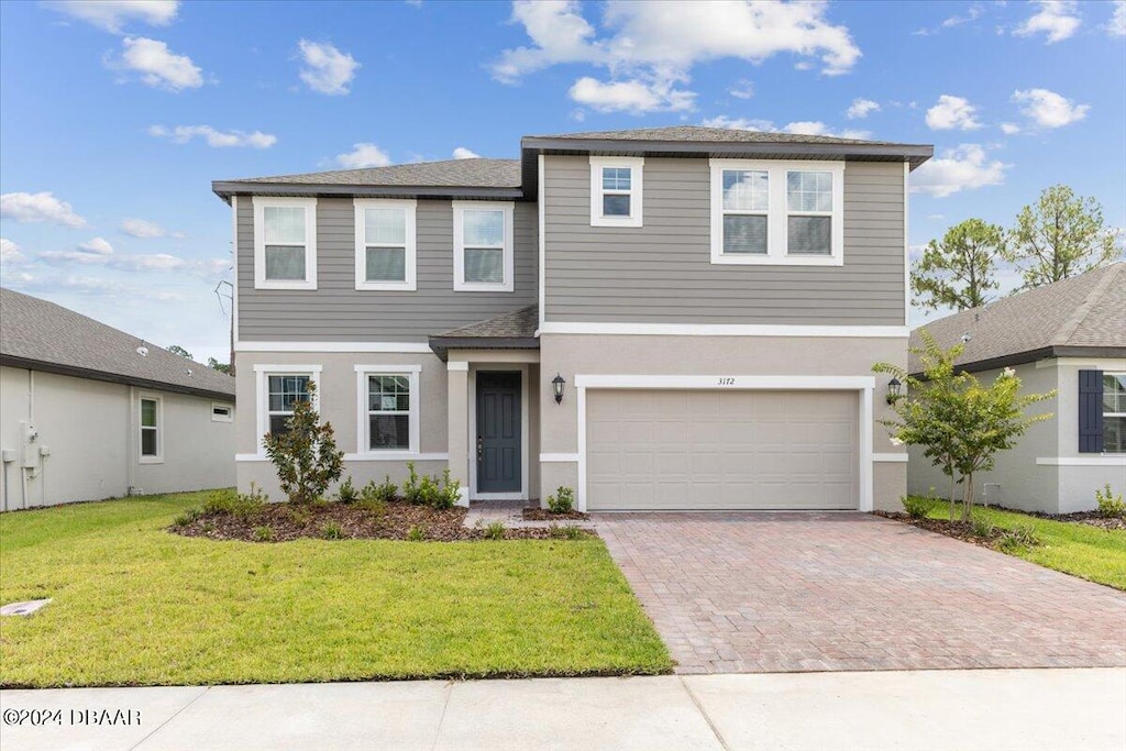 view of front of home with a garage and a front lawn