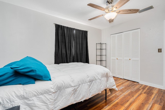 bedroom with hardwood / wood-style floors, ceiling fan, and a closet