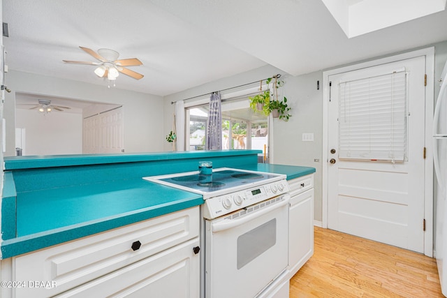 kitchen featuring white electric range oven, light wood-type flooring, and white cabinetry