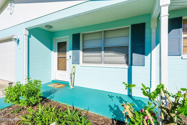 property entrance featuring a porch and a garage