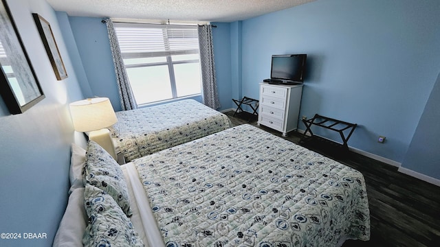 bedroom featuring dark hardwood / wood-style flooring and a textured ceiling