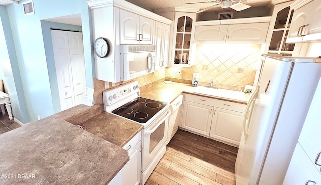 kitchen with light wood-type flooring, white appliances, decorative backsplash, and ceiling fan