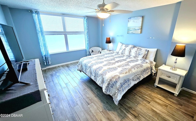 bedroom featuring ceiling fan, a textured ceiling, and dark hardwood / wood-style flooring