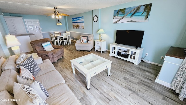 living room with a textured ceiling, hardwood / wood-style flooring, and ceiling fan