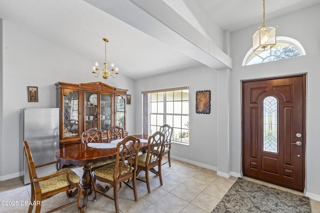 dining space with lofted ceiling, baseboards, a notable chandelier, and light tile patterned flooring