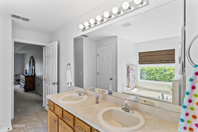 bathroom featuring visible vents, a sink, and tile patterned floors