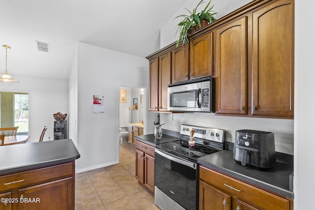 kitchen featuring visible vents, dark countertops, stainless steel appliances, pendant lighting, and light tile patterned flooring