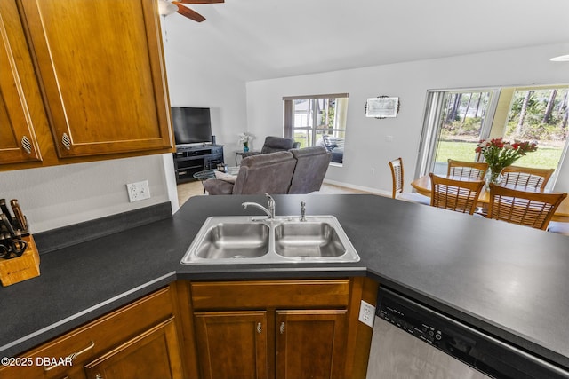 kitchen featuring a sink, open floor plan, brown cabinets, dishwasher, and dark countertops