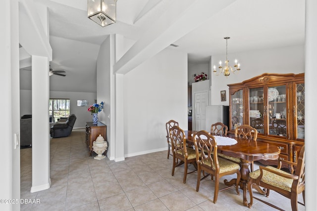 dining area featuring ceiling fan with notable chandelier, light tile patterned flooring, lofted ceiling, and baseboards