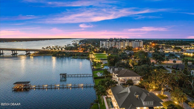 aerial view at dusk featuring a water view