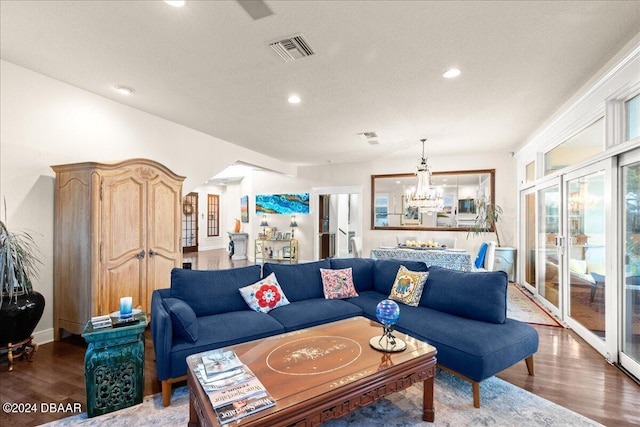 living room featuring a textured ceiling, a notable chandelier, and hardwood / wood-style flooring