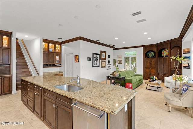 kitchen featuring light stone counters, dishwasher, sink, an island with sink, and crown molding